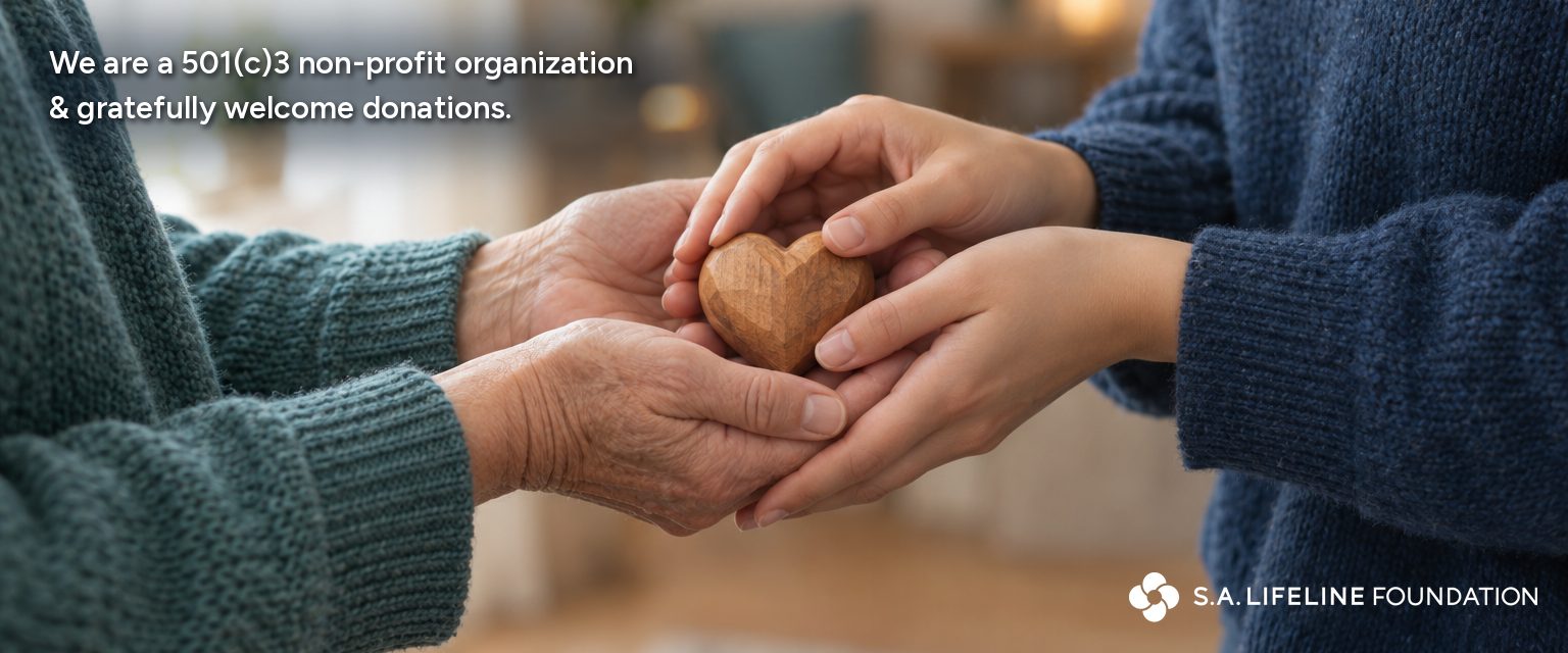 Two pairs of hands together holding a small carved wooden heart